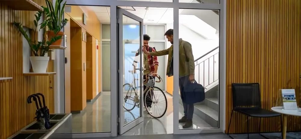 Unsuspecting employee holding door for a tailgater